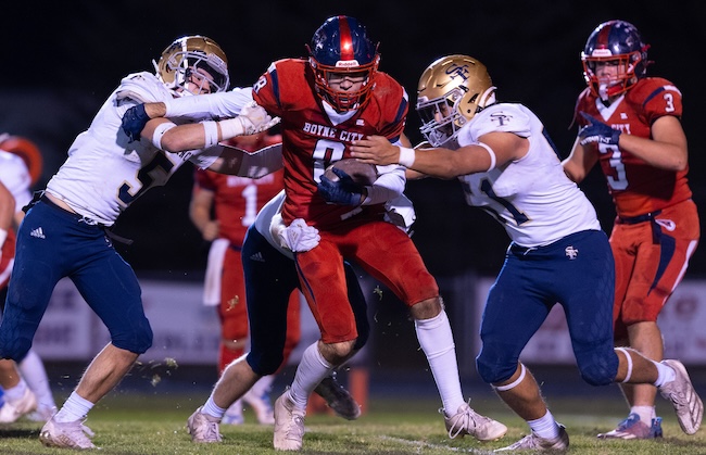 Ben Stanek (8) works to break free from a pair of Traverse City St. Francis defenders during a 23-20 Week 9 win over Traverse City St. Francis. 