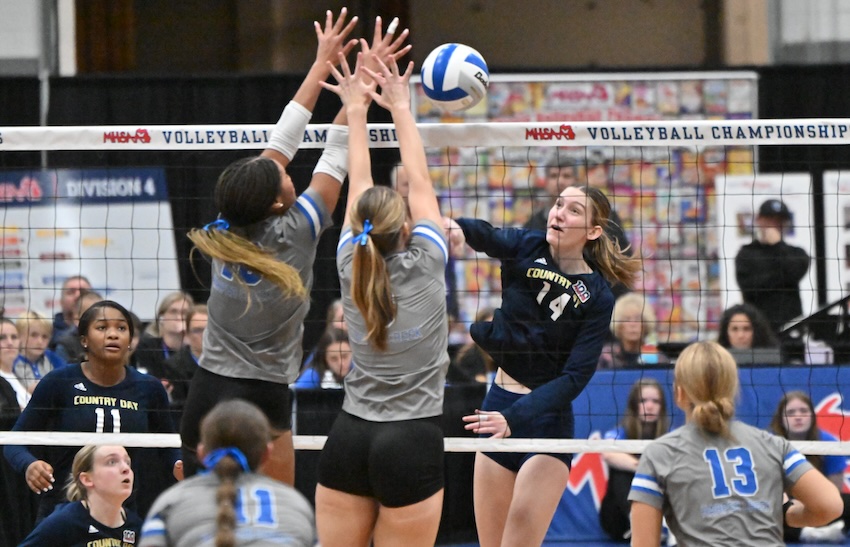 Detroit Country Day’s Leah Green (14) unleashes a spike toward a Battle Creek Harper Creek block during the Yellowjackets’ 25-14, 24-26, 25-17, 25-23 victory in Division 2. Green had six kills and four blocks.