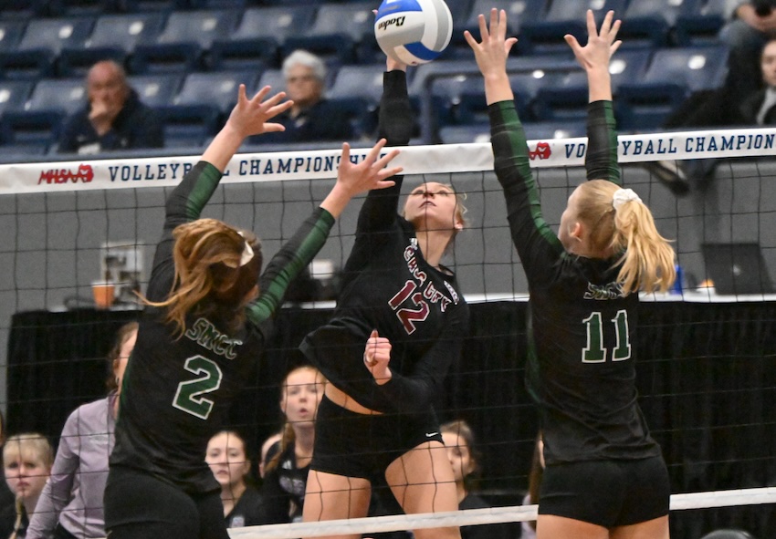 Cass City’s Lexi Champagne (12) sends a ball toward the blocks of St. Mary’s Olivia Beaudrie (2) and McKenna Payne (11). Beaudrie had three blocks and Payne two for the match, and Champagne finished with four kills and 13 digs for the Red Hawks (37-10-1).