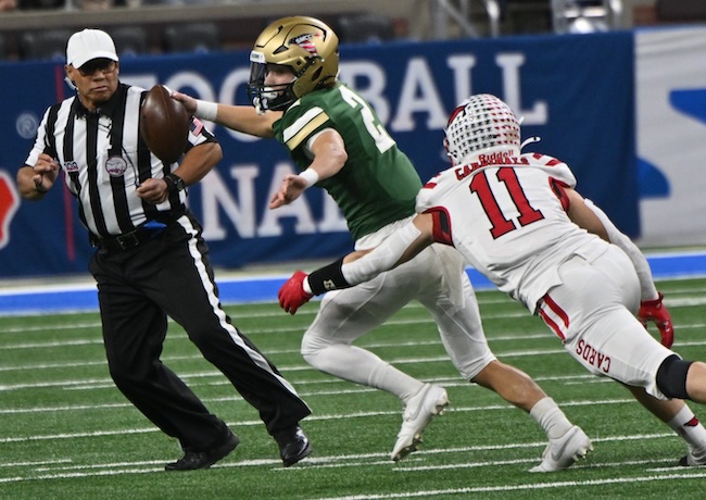 The Cardinals’ Brevin Hendricks (11) chases SMCC quarterback Ian Foster in the backfield. 