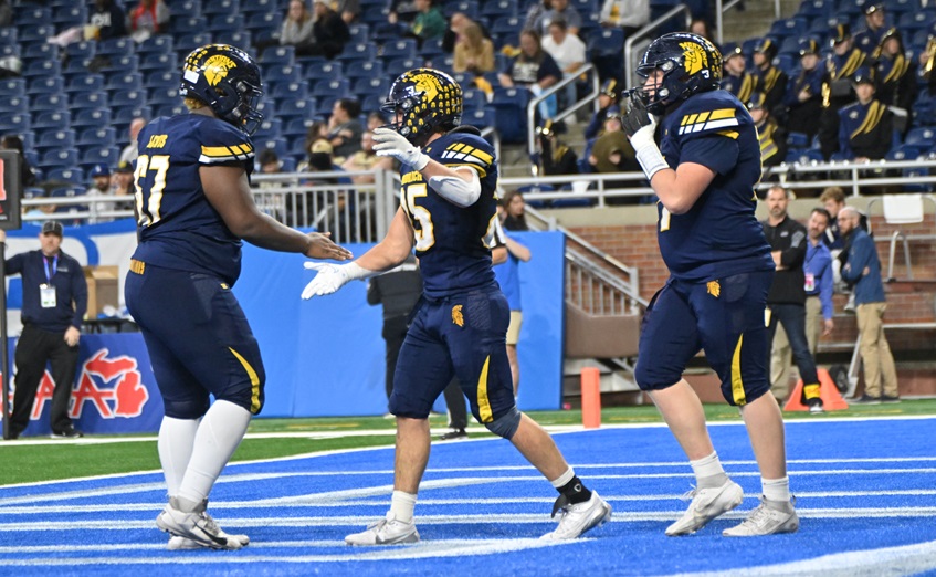 Goodrich's Chase Burnett, middle, celebrates his touchdown with two of his linemen.