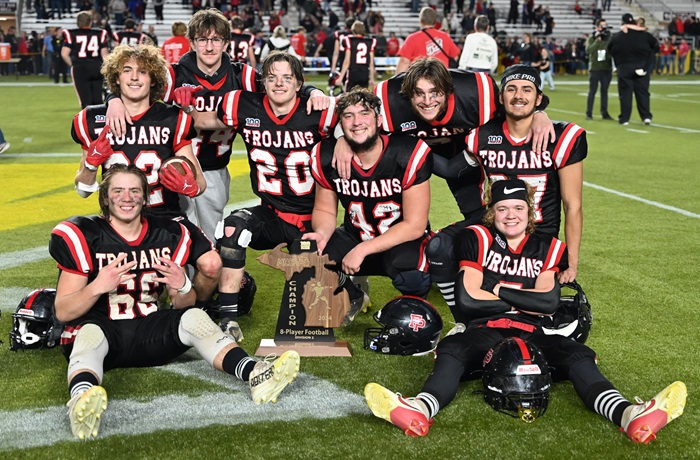 The Trojans’ seniors take a photo with the program’s fifth championship trophy. 