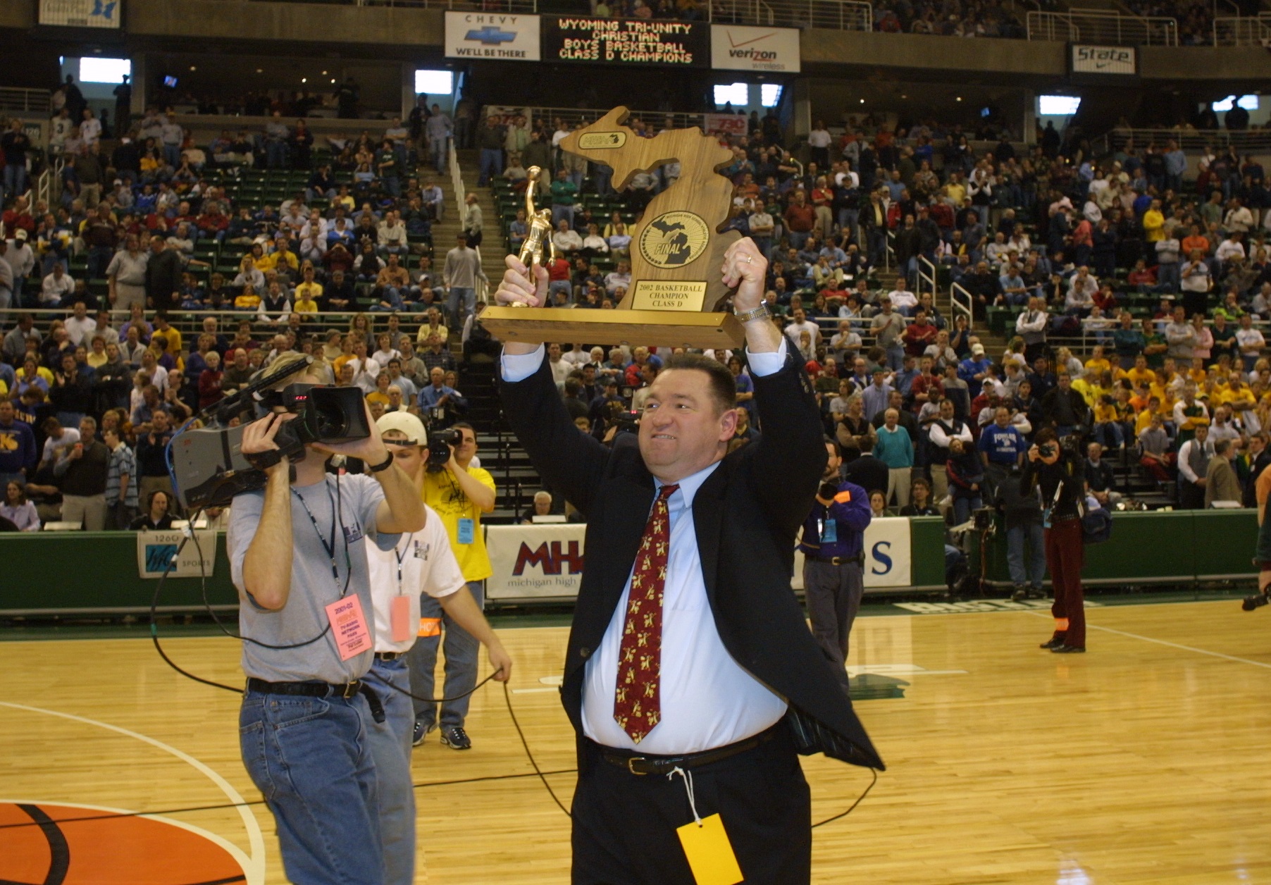 Keeler raises the 2002 Class D championship trophy to the cheers of Tri-unity’s supporters. 