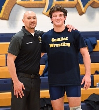 Cadillac coach Eli Hoffert, left, stands with Phillips.