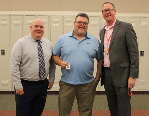 Dowagiac assistant superintendent Michael Dunn, left, and Blomgren present Dowagiac Middle School science teacher Pat Lyle with a pin for 30 years of service.