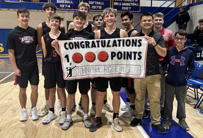 Howardsville teammates and members of the coaching staff celebrate Rose reaching 1,000 career points against St. Joseph Our Lady of the Lake Catholic.