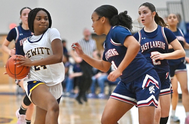 DeWitt’s Golden Nicholson (24) drives to the basket with Lundyn Elam (4) defending during the Panthers’ 55-35 District title win over East Lansing in Division 1.