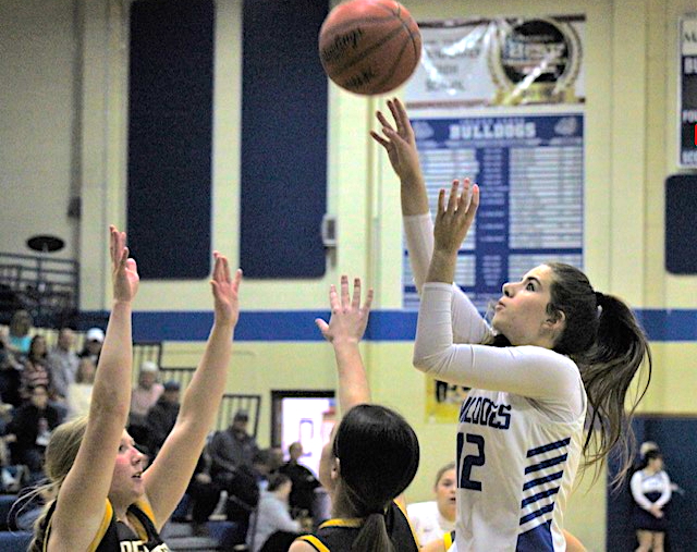 Junior Chloe Robinson (12) puts up a jumper over a pair of defenders. 