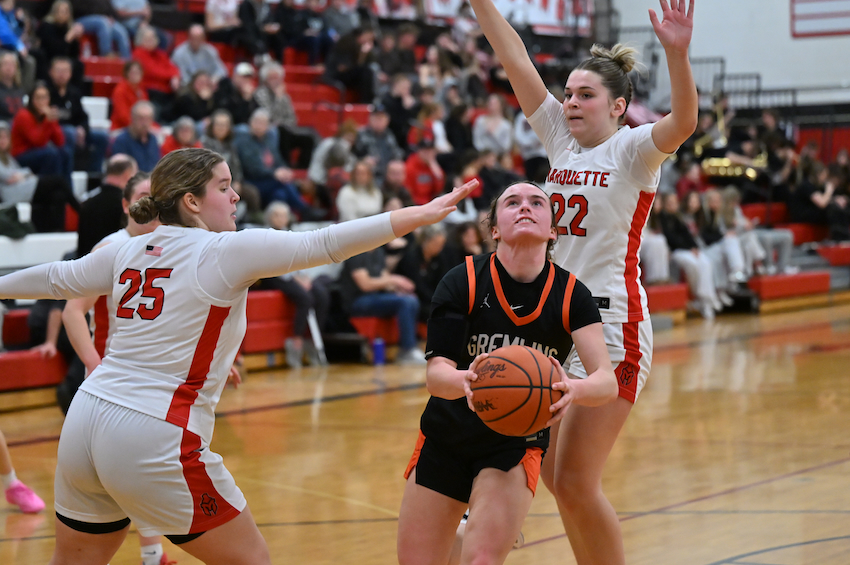 Houghton's Kate Filpus cuts between Marquette's Kylie Smith (25) and Hayley Taylor (22) and takes a shot.